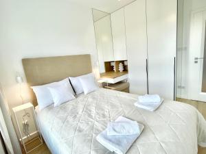 a bedroom with a large white bed with towels on it at EASY RENT- Apartament z Widokiem in Lublin +12 photos
