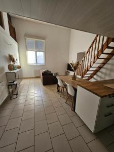 ein Wohnzimmer mit einer Küche und einer Treppe in der Unterkunft Jolie appartement près de la plage in Berck-sur-Mer