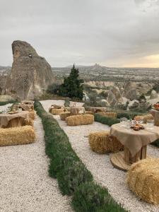 a group of tables and hay bales on a field at Wish Cappadocia Love in Uchisar