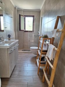 a bathroom with a toilet and a sink and a tub at Ortensia in Oziás +46 photos