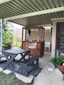 - une table de pique-nique sous un auvent sur une terrasse dans l'établissement Jacobs Cottage by the Ocean, à Port Shepstone