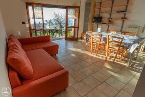 un salon avec un canapé, une table et des chaises dans l'établissement Casa Vacanze Casa Barbara, à Finale Ligure