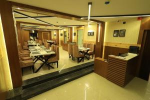 a restaurant with a dining room with tables and chairs at The Hotel SAAJ-Premium in Bhubaneshwar