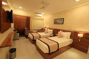 a hotel room with two beds and a television at The Hotel SAAJ-Premium in Bhubaneshwar