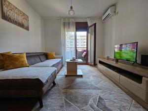a living room with a couch and a flat screen tv at Luča apartman in Podgorica