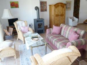 een woonkamer met een bank en stoelen en een open haard bij House Thor - Huus Asgard in Nieby