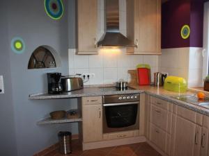 a kitchen with wooden cabinets and a stove top oven at Morning sun Comfortable holiday residence in Westerstede