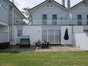 een wit huis met een patio met een tafel en een parasol bij House Thor - Huus Asgard in Nieby +13 foto's