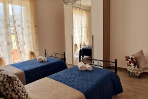 a bedroom with two beds with towels on them at Bella Piana Home in Brolo