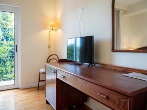 a tv on a wooden dresser in a room at Hotel Altamira in Orsogna