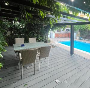 a table and chairs on a deck next to a swimming pool at A Detached Floor in Parekklisha +5 photos