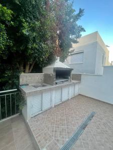 a outdoor kitchen with a grill on a patio at A Detached Floor in Parekklisha