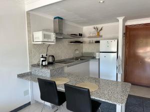 kuchnia z blatem z krzesłami i lodówką w obiekcie Marbesa Marbella Apartment w Marbelli