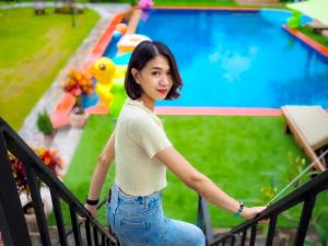 Ban Tha MaprangにあるRest On Hillのプールの前の手すりに座っている女性