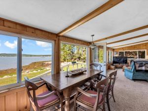 ein Esszimmer mit Tisch und Stühlen und Fenstern in der Unterkunft Two-Bedroom House in Milbridge