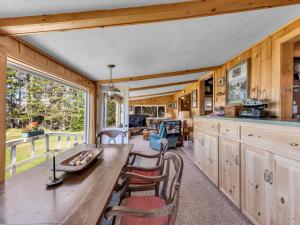eine Küche mit einem langen Holztisch und Stühlen in der Unterkunft Two-Bedroom House in Milbridge
