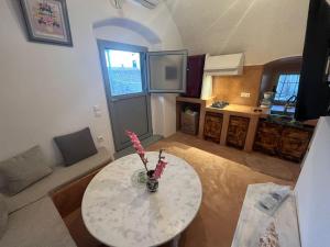 ein Wohnzimmer mit einem Tisch und einer Küche in der Unterkunft Case De Drymona 2 in Kýthira + 3 Fotos