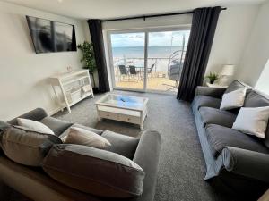 ブリドリントンにあるSeaside Escapes, Bridlingtonのソファがあり海が見えるリビングルーム