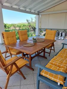 a wooden table and chairs on a patio at The Three Palms Samos Seaside Villa in Mesókampos