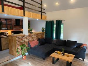 a living room with a blue couch and a table at Domek do 12 osób, balia z jacuzzi in Małszewko