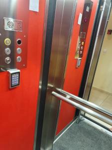 Un ascensor con paredes rojas y una puerta de metal. en Apartmani Vesna Luxury & Stefan ap 4, en Paralia Katerinis