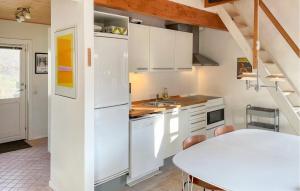 a kitchen with white cabinets and a table at One-Bedroom Holiday Home In Kalundborg in Kalundborg