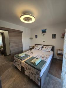 Un dormitorio con una cama grande con toallas. en Apartmani Plavšić, en Novi Vinodolski