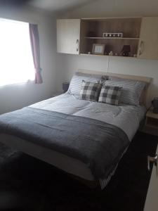 a large bed in a bedroom with a window at Haven Skegness 20 Donna Nook in Skegness