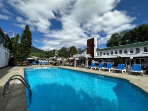 a large swimming pool with blue chairs and a building at O'Sullivan's Motel in Lake George