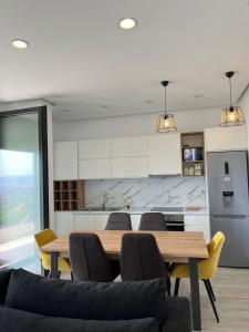 a living room with a table and chairs and a kitchen at Apartment with view in Tirana in Shkozë