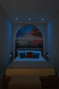 a bedroom with a large bed with a painting on the wall at Dimora del Corso Luxury house in Pescara +21 photos