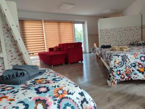 a bedroom with two beds and a red couch at Al Nido in Pietramurata