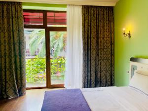 a bedroom with a bed and a large window at Apartment Maisi in Batumi