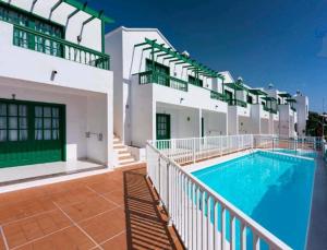 a large building with a swimming pool in front of it at Bright & spacious with aircon in Puerto del Carmen