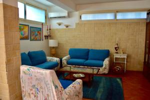 a living room with a blue couch and chairs at Casamia in Avola