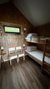 a bedroom with two bunk beds and two chairs at Base Camp Hamarøy in Sørkil
