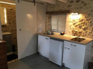 a kitchen with a sink and a counter top at Au cœur du jardin in Souvigné