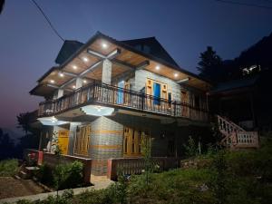 a house with a balcony and lights on it at Paras Homestay in Shoja