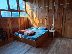 a bedroom with a bed in a wooden room at Paras Homestay in Shoja +3 photos