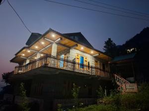 a house with a balcony with lights on it at Paras Homestay in Shoja