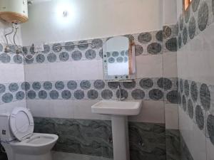 a bathroom with a sink and a toilet at Paras Homestay in Shoja