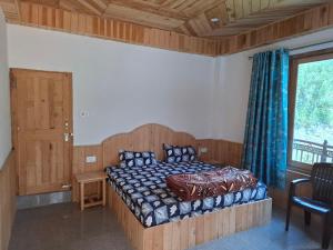 a bedroom with a bed with a wooden headboard and a window at Paras Homestay in Shoja