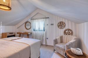 a bedroom with a bed and a chair at Dimitra's Paradise Villa in Lygia