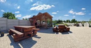a pavilion with wooden benches and a picnic table at Casa Gimi in Baile Unu Mai
