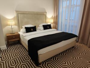 a bedroom with a large bed and a large window at Hotel Royal & Spa in Białystok
