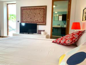 una camera con un grande letto bianco e una TV a schermo piatto di Daydream a Trabia