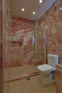 a bathroom with a toilet and a glass shower at Gold Waves Luxury Studios by Pieria Riviera in Paralia Katerinis