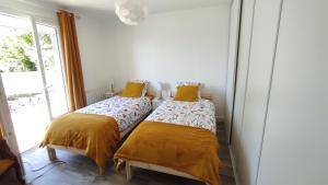 two beds in a room with a window at Les Bordaiseries in La Réorthe