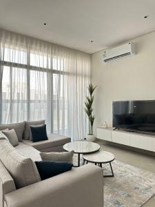 a living room with a couch and a tv at Luxury Modern Apartment with Gym and Lounge in Riyadh