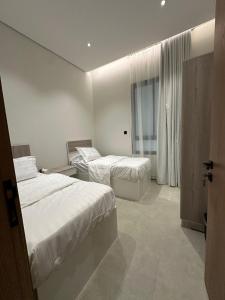 a hotel room with two beds and a window at Luxury Modern Apartment with Gym and Lounge in Riyadh